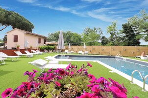 Una piscina al aire libre de temporada, sombrillas