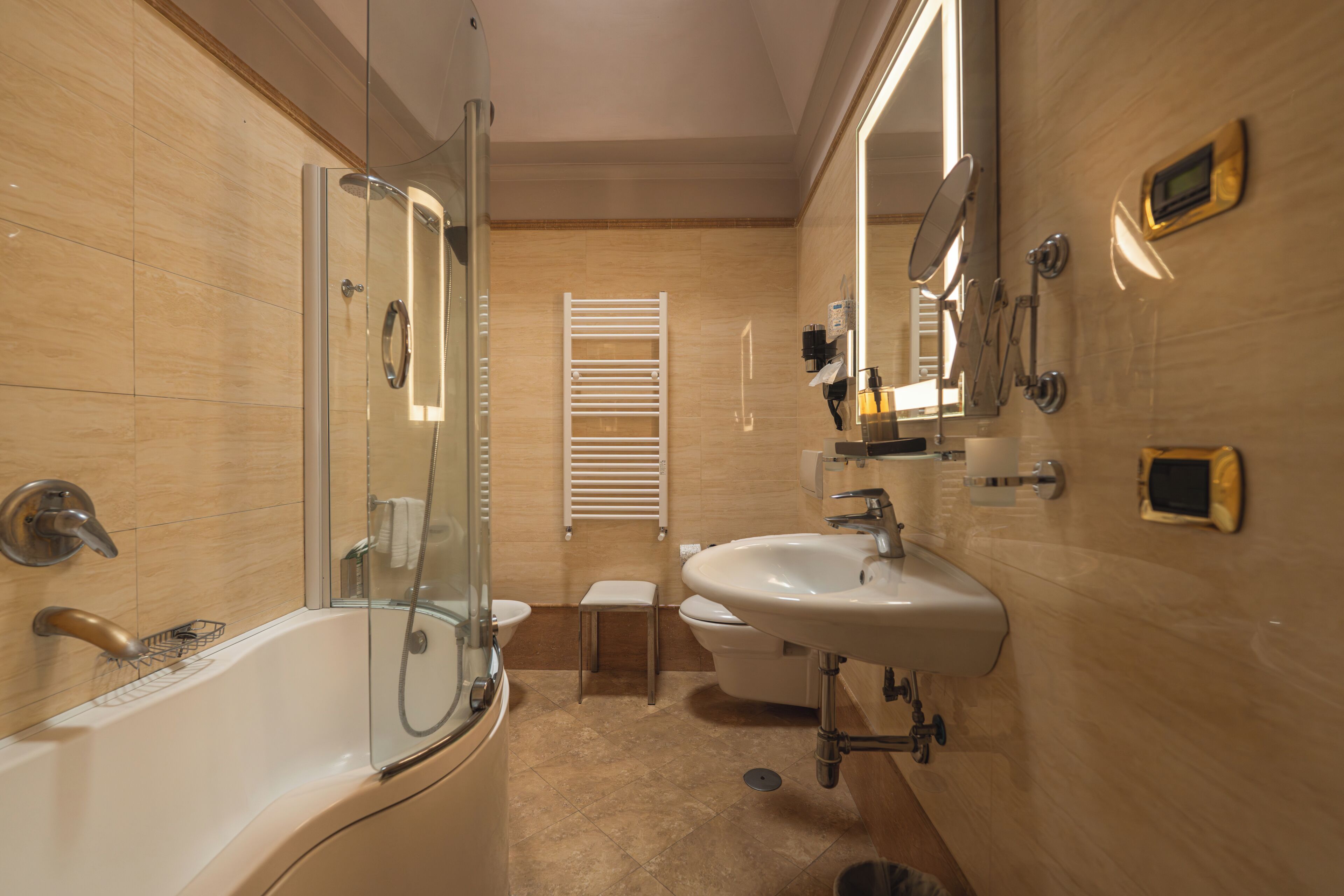 A modern bathroom with a glass-enclosed shower, a standalone sink, and a toilet.