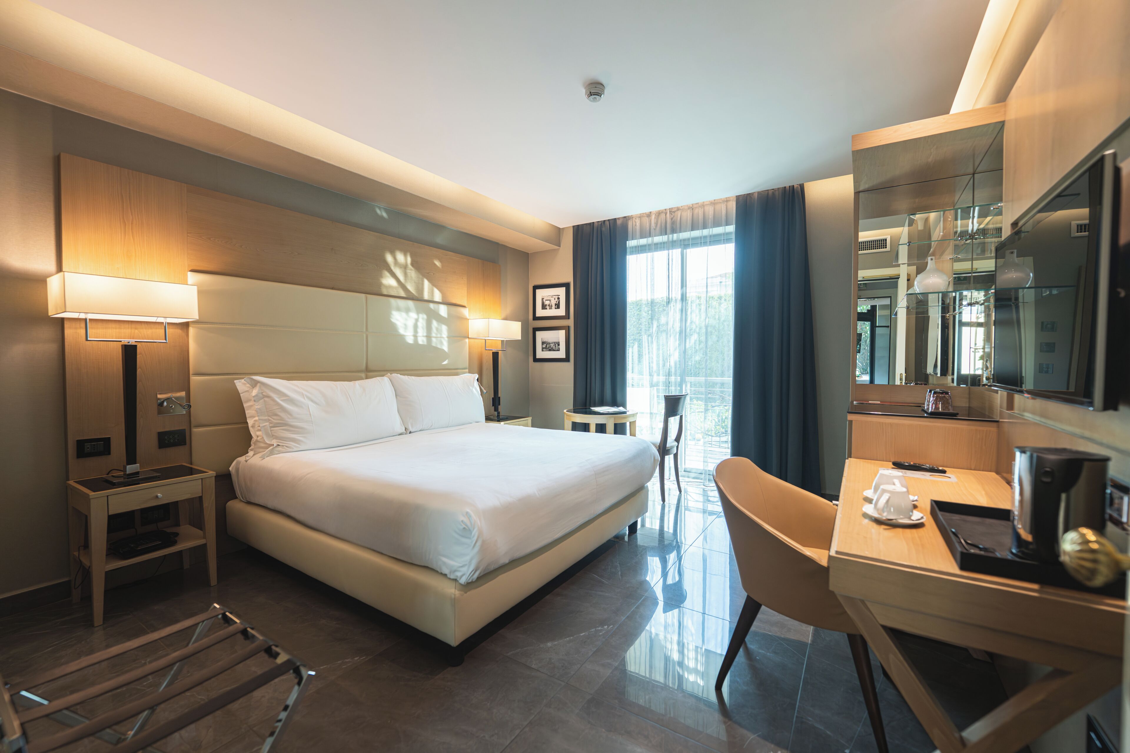 Een hotelkamer met een bed, bureau, stoel en een televisie.