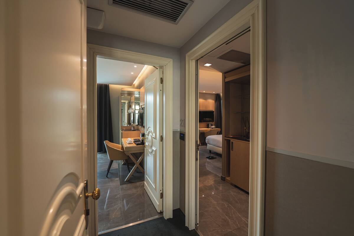 A hotel room with a bed, bedside table, and a bathroom with a shower and toilet.