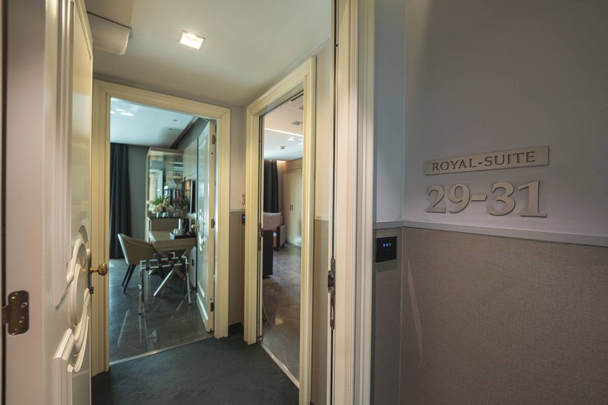A hotel corridor with a sign indicating 'ROYAL-SUITE 29-31'.