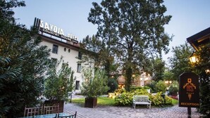 A country hotel with a reception area, paved courtyard, and surrounding greenery. - Savoia Hotel Country House (Bologna)