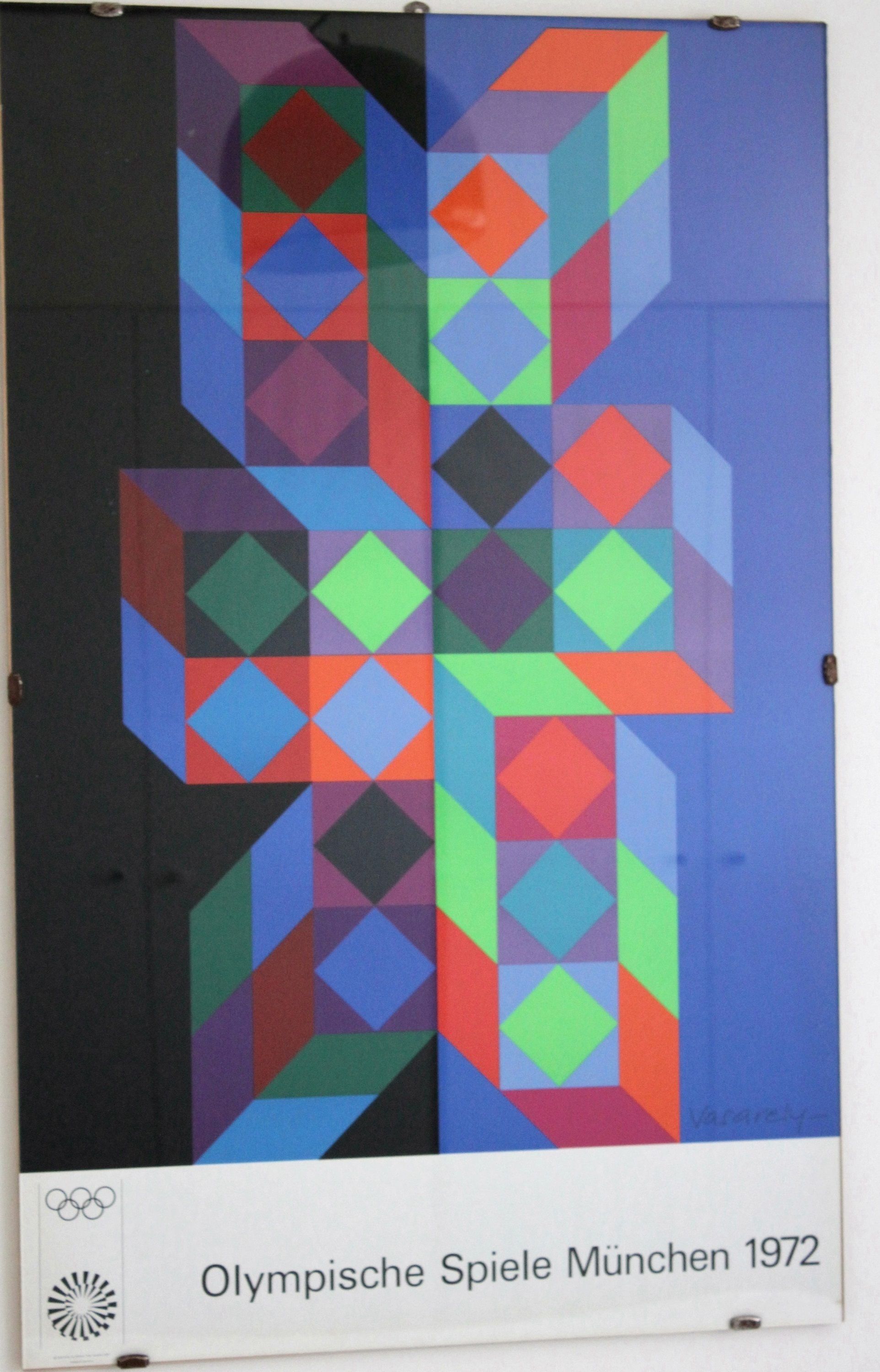 A colorful geometric artwork titled "Olympische Spiele München 1972" mounted on a wall.