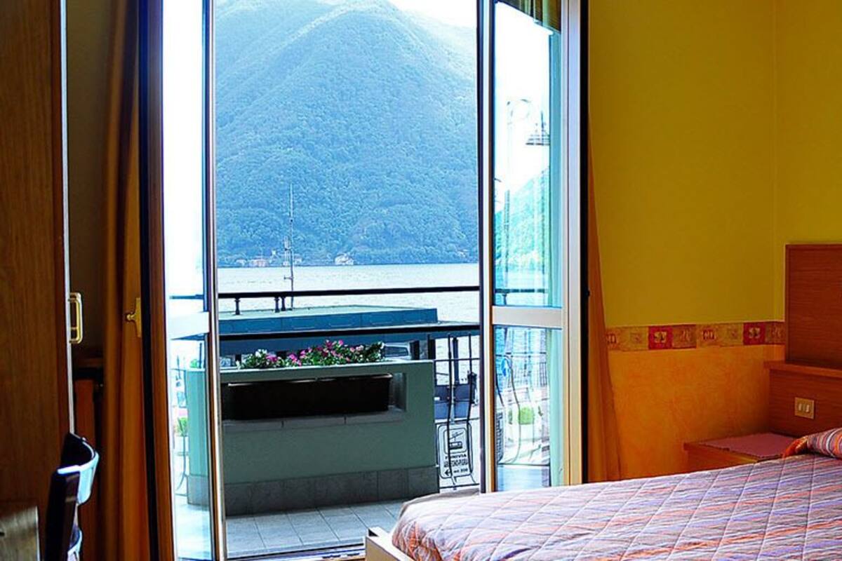 Ein Schlafzimmer mit Bett, Fenster und Bergblick.