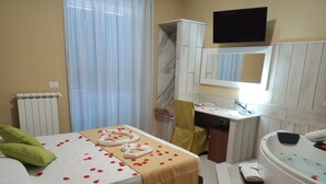 Una habitación de hotel con cama, escritorio, tocador y bañera.