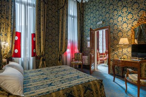 Una stanza con un letto, una scrivania, una sedia e uno specchio.