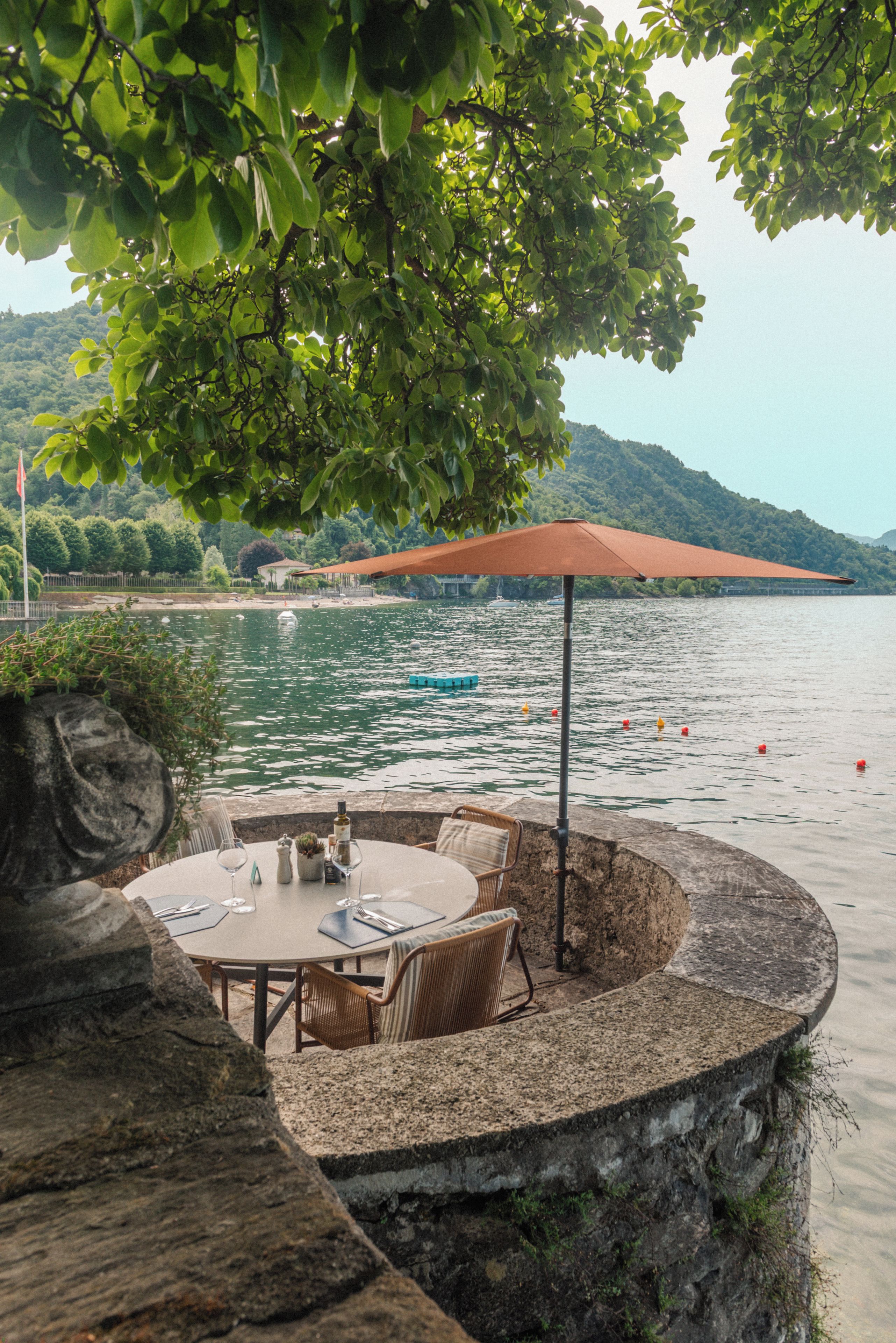 Comedor con una mesa y sillas, con vistas a un lago con barcos.