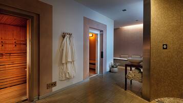 A hallway with a wooden door, a towel rack, a sink with a bowl, and a tiled wall.