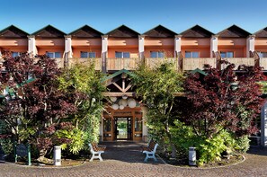 Stunning hotel facade with a central entrance, covered walkway, and beautifully landscaped surroundings.