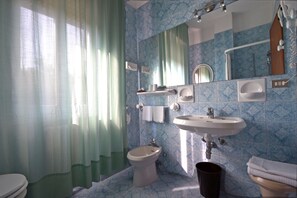 A bathroom with a bidet, a sink, a toilet, and a mirror. - Albergo Boomerang (Salsomaggiore Terme)