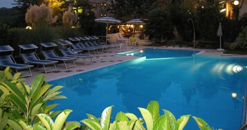 Una piscina al aire libre de temporada, sombrillas
