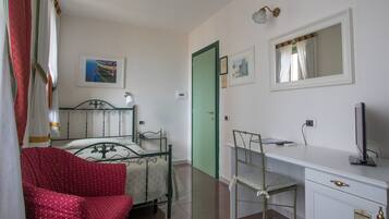 Un dormitorio con cama, escritorio, silla y armario.