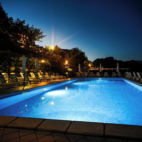 Piscine extérieure en saison, chaises longues