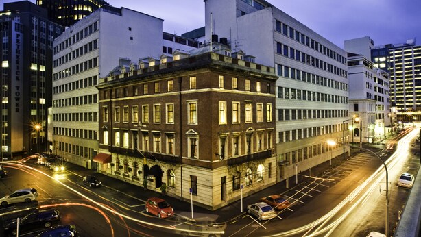 A multi-story building with a classic architectural design, featuring large windows and a central courtyard.