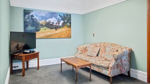 A living room with a sofa, a coffee table, and a TV on a stand.