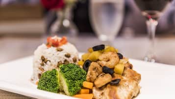 A plate of food with rice, broccoli, carrots, and chicken.