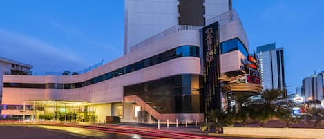 Un edificio moderno con una estructura vertical destacada y un cartel de casino.