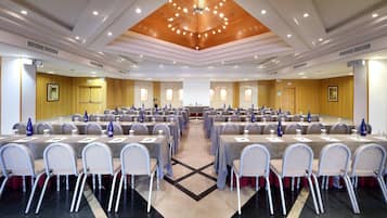 Un salón de conferencias con varias mesas y sillas, equipado con tarjetas de identificación y botellas de agua.