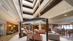 A spacious lobby with a high ceiling, multiple seating areas, and a modern design. - Hotel Exe Getafe (Getafe)