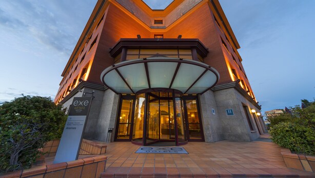 A hotel entrance with a glass door, a sign indicating it is the Excalibur Hotel, and a tiled walkway leading to the entrance. - Hotel Exe Getafe (Getafe)
