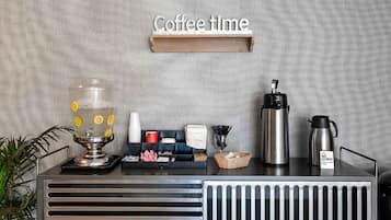 A coffee station with a coffee grinder, a coffee pot, and a water dispenser.