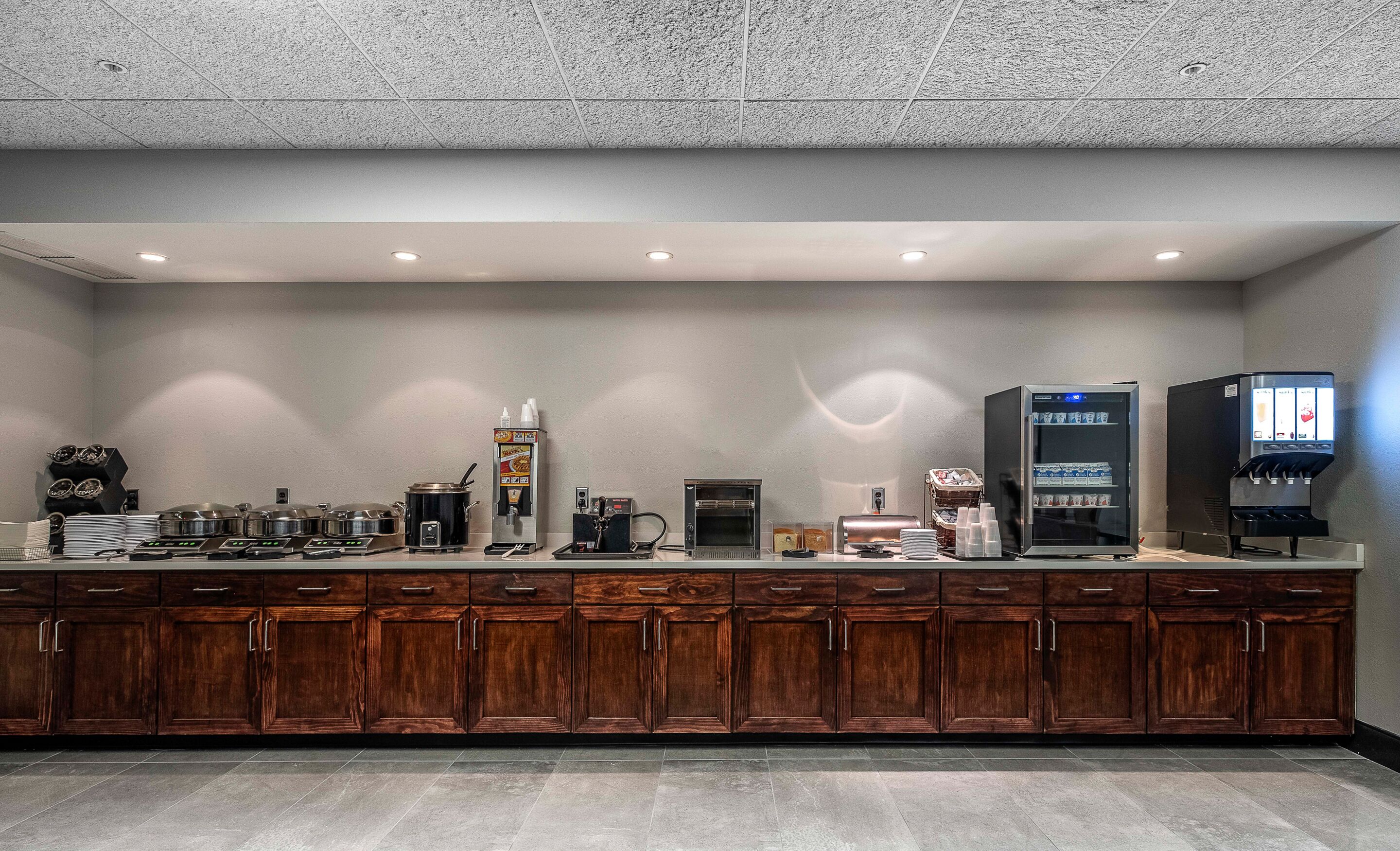 A commercial kitchen with various appliances, including a coffee machine, a microwave, and a refrigerator.