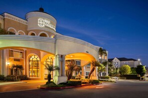 A hotel with a dome and arched entrance, a fountain, and palm trees. - Hotel Marguerite Anaheim/Garden Grove, Trademark Collection by Wyndham (Garden Grove)