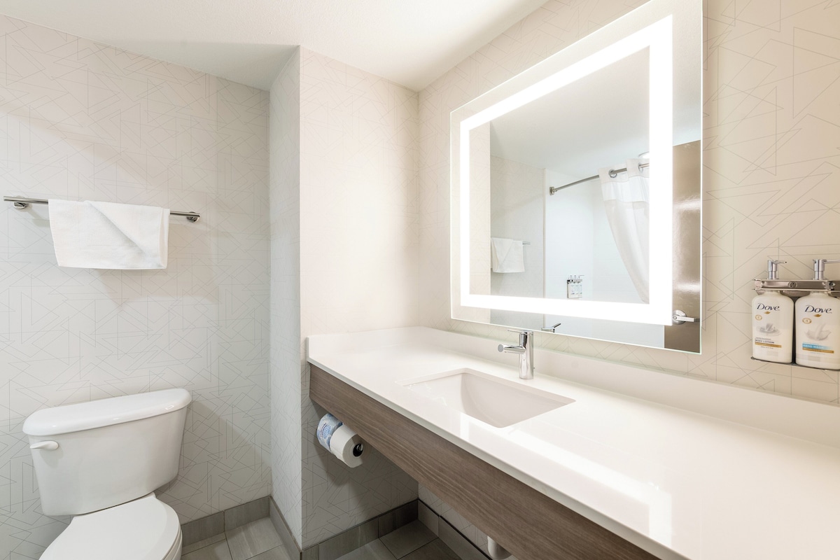 Une salle de bain moderne avec des toilettes, un lavabo et un miroir.