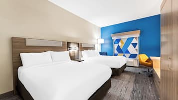 Ein Hotelzimmer mit zwei Betten, einem Schreibtisch, einem Stuhl und einem Kleiderschrank.