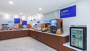 A breakfast area with a counter displaying food items and a refrigerator with a digital display. - Holiday Inn Express Harvey-Marrero by IHG (Harvey)