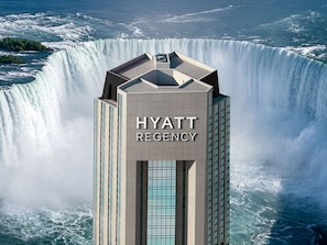A tall building with the text 'HYATT REGENCY' on its facade, surrounded by a large waterfall. - Hyatt Regency Niagara Falls Fallsview (Niagara Falls)