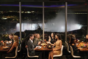 A group dining at a table with a view of a waterfall.