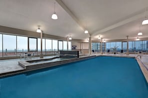 Una piscina techada, sillones reclinables de piscina