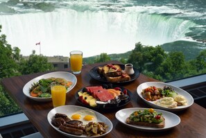 A table with breakfast items and a glass of orange juice, overlooking a waterfall. - Hyatt Regency Niagara Falls Fallsview (Niagara Falls)