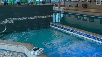 Een binnenzwembad, ligstoelen bij het zwembad