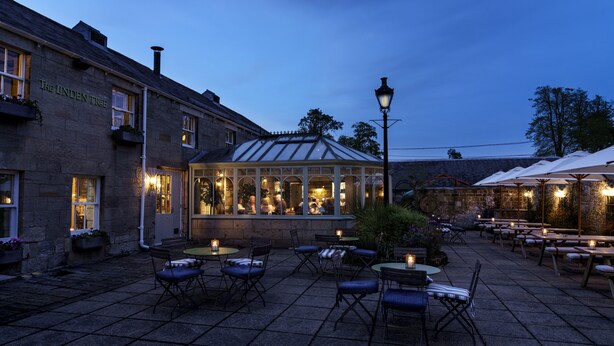 A courtyard with outdoor seating, a conservatory, and a stone building labeled "The Lunden Tree". - Macdonald Linden Hall Golf & Country Club (Morpeth)