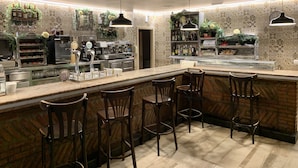 A bar area with a counter, bar stools, and a coffee machine. - Hotel Cueli (Santillana del Mar)