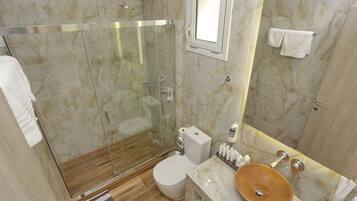 Ein modernes Badezimmer mit einer gläsernen Duschkabine, einem Marmorboden, einem hölzernen Waschtisch mit einer Schüssel und einer Toilette.
