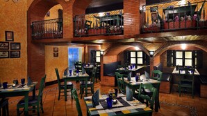 Ein Restaurant mit Backsteinwänden, grünen Stühlen und gedeckten Tischen.