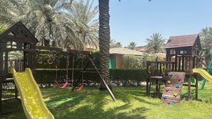 Ein Spielplatz mit Rutsche, Schaukeln und Klettergerüsten.