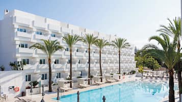 Una piscina al aire libre, sombrillas, tumbonas