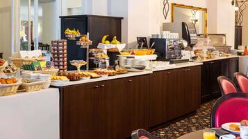 Un buffet de petit-déjeuner proposant une variété d’aliments et un coin café.