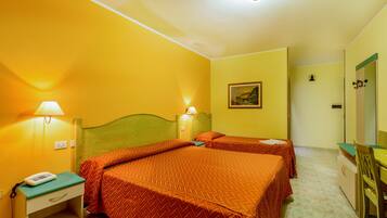 A hotel room with two beds, a desk, a chair, a lamp, and a painting on the wall.