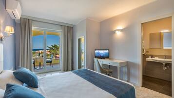 Ein Hotelzimmer mit Bett, Schreibtisch, Fernseher und Badezimmer.