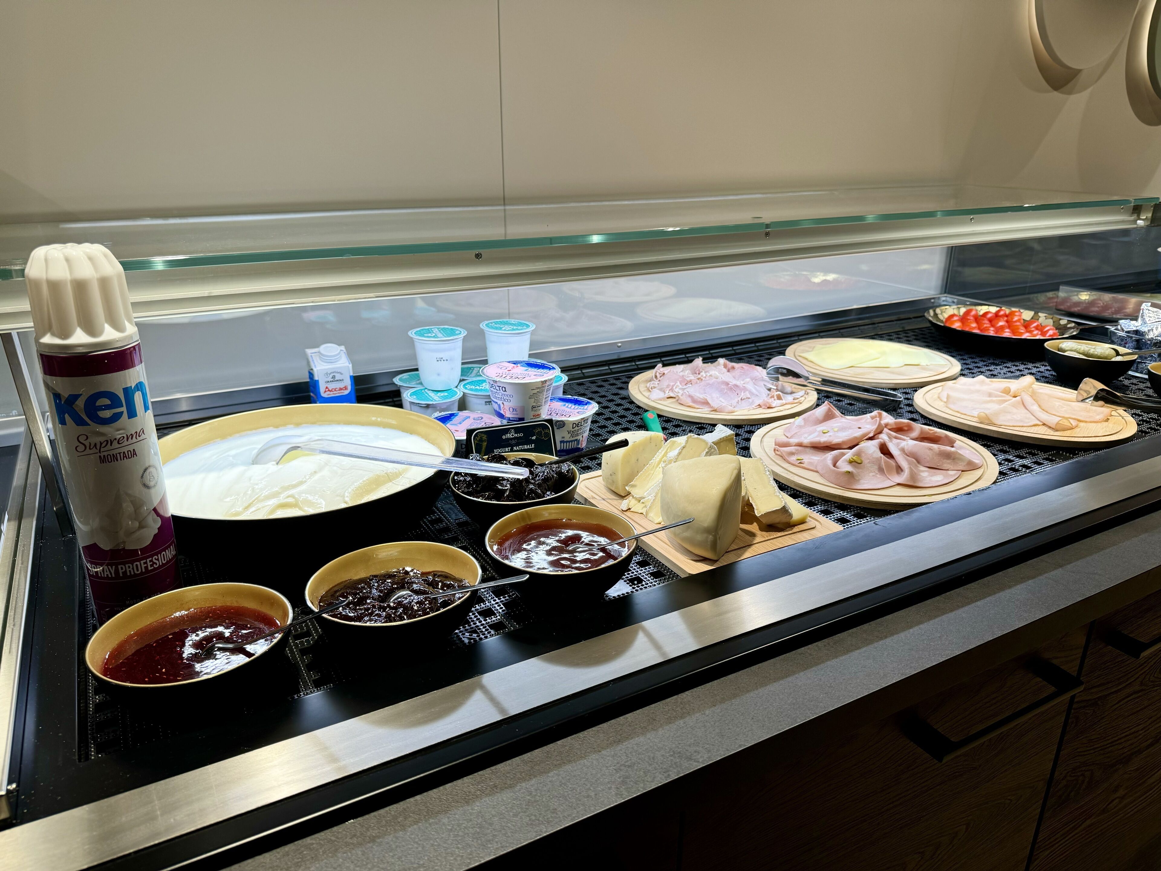 A buffet with various food items including cheese, meats, and condiments.