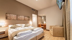 A modern hotel room with a large bed, a desk, a chair, and a TV mounted on the wall. - Hotel All'Orso (Roncade)