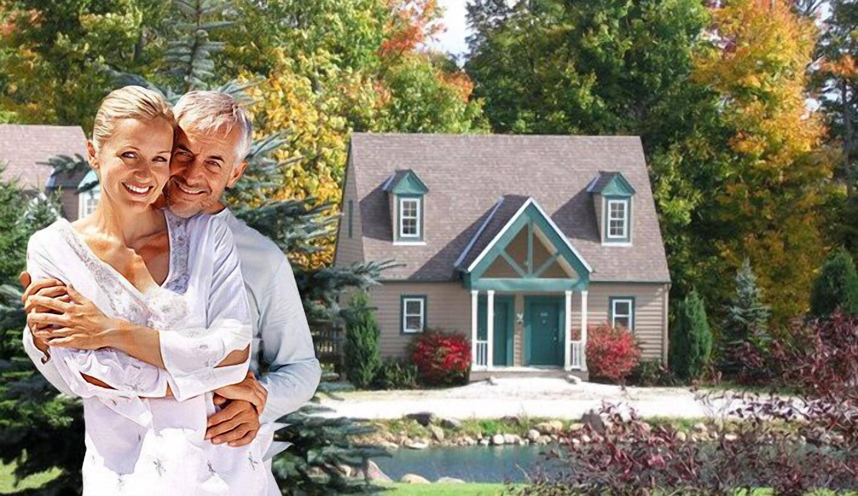 A couple embracing in front of a house with a pond and a well-maintained garden.