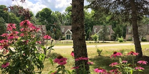 A residential area with multiple houses, a grassy lawn, and flowering plants. - Spruce Hill Inn and Cottages (Mansfield)