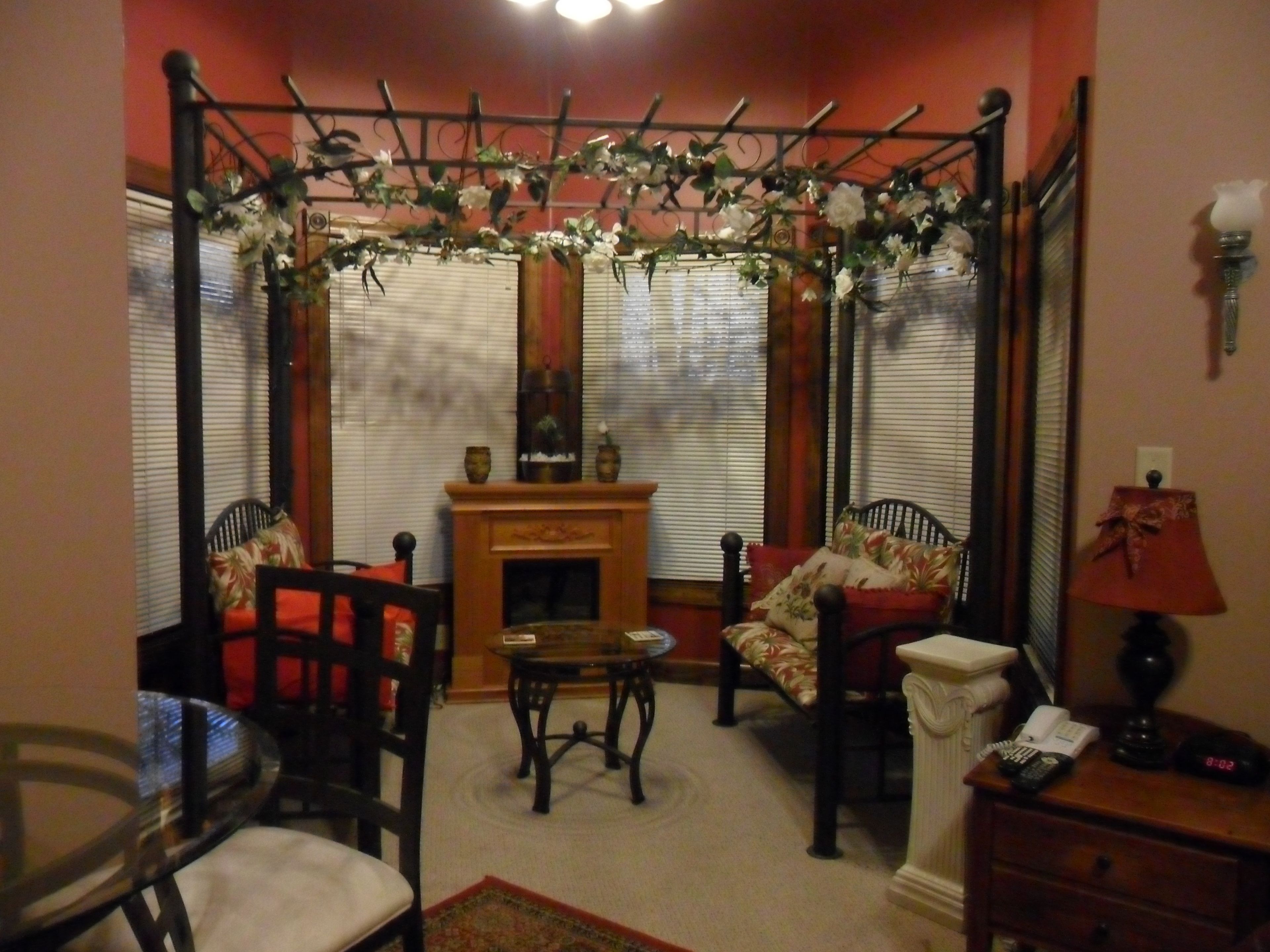 A living room with a fireplace, a coffee table, two chairs, and a sofa.
