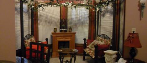 A living room with a fireplace, a coffee table, two chairs, and a sofa.